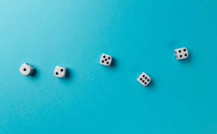 Photo of five six-sided dice on a blue background.